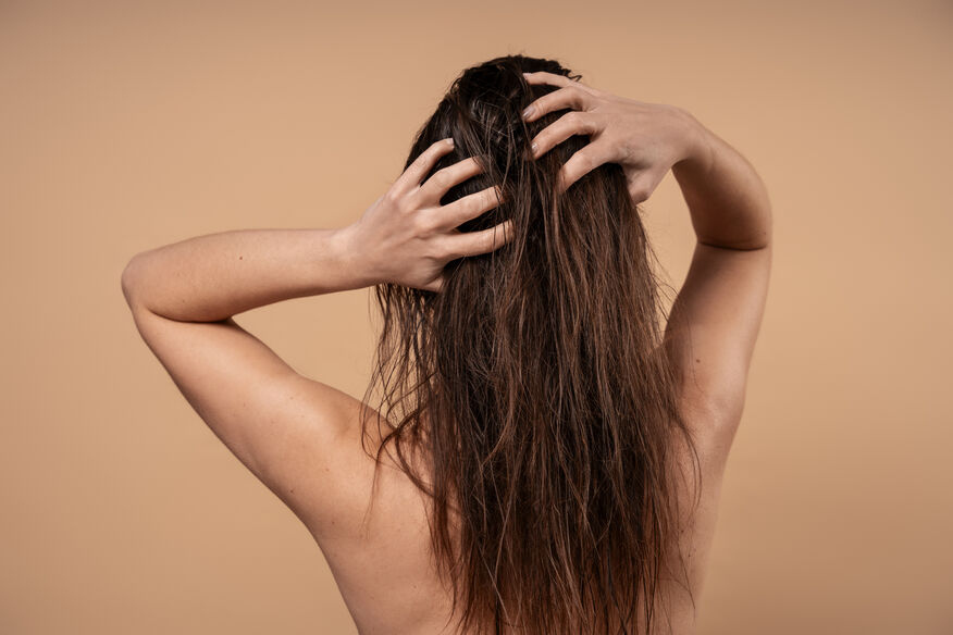 A clean flat lay image of shampoo, conditioner, leave-in conditioner, and hair oil for a simple beginner hair porosity routine.