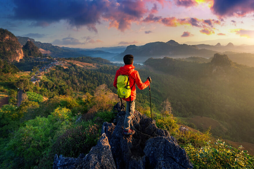 A solo traveler standing near a mountain or beach viewpoint, enjoying the peaceful experience of traveling alone.